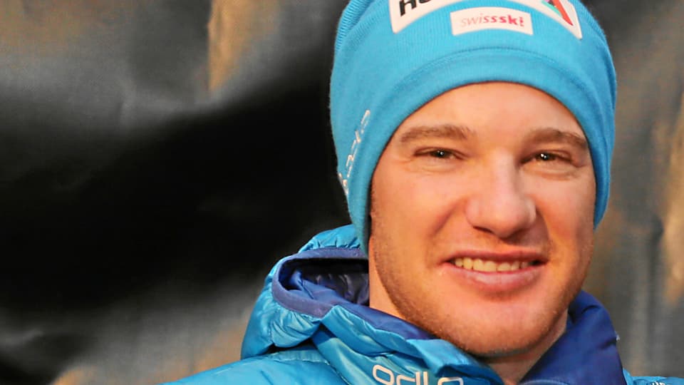Dario Cologna cun chapetscha blaua e giacca blaua