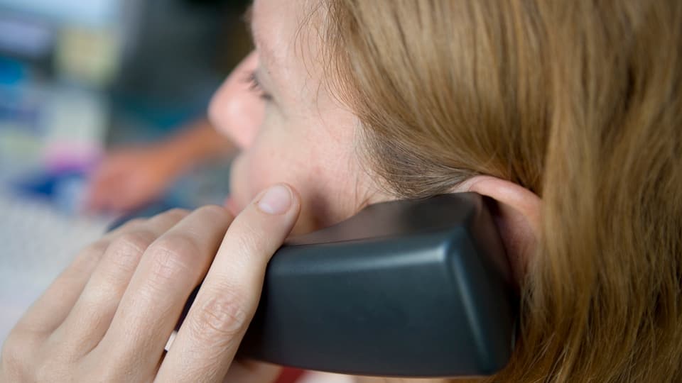 Ina giuvna che telefonescha.
