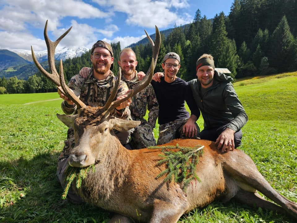 Vier Jäger mit einem Hirschstier.