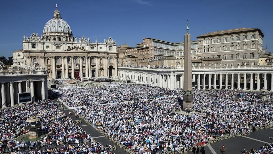 La plazza da surengiu cun millis e millis da persunas sut tschel blau.