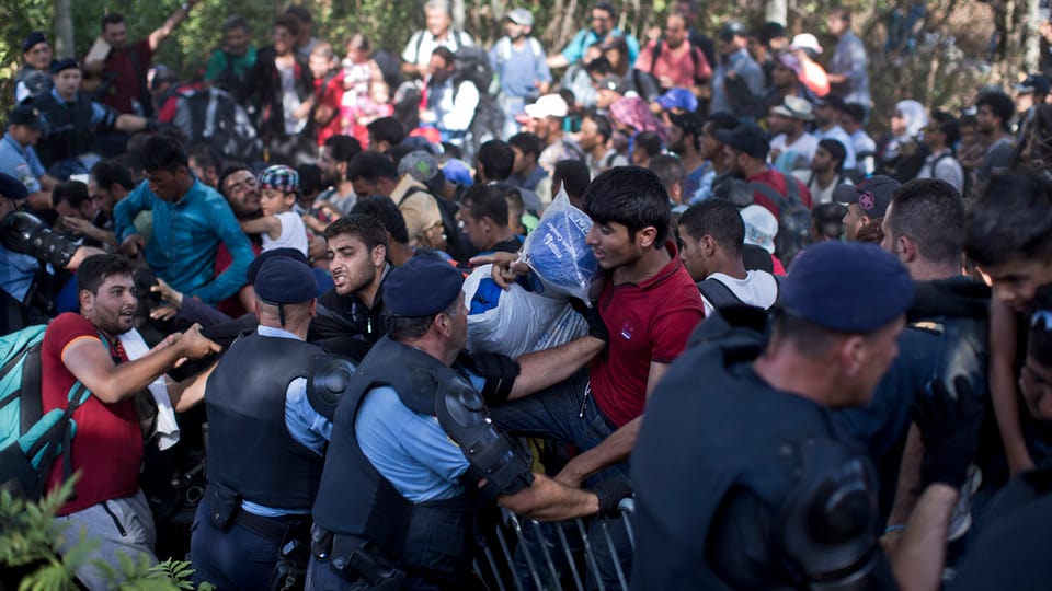 Persunas che sa fultschan cun tutta forza sur las barricadas da la polizia.