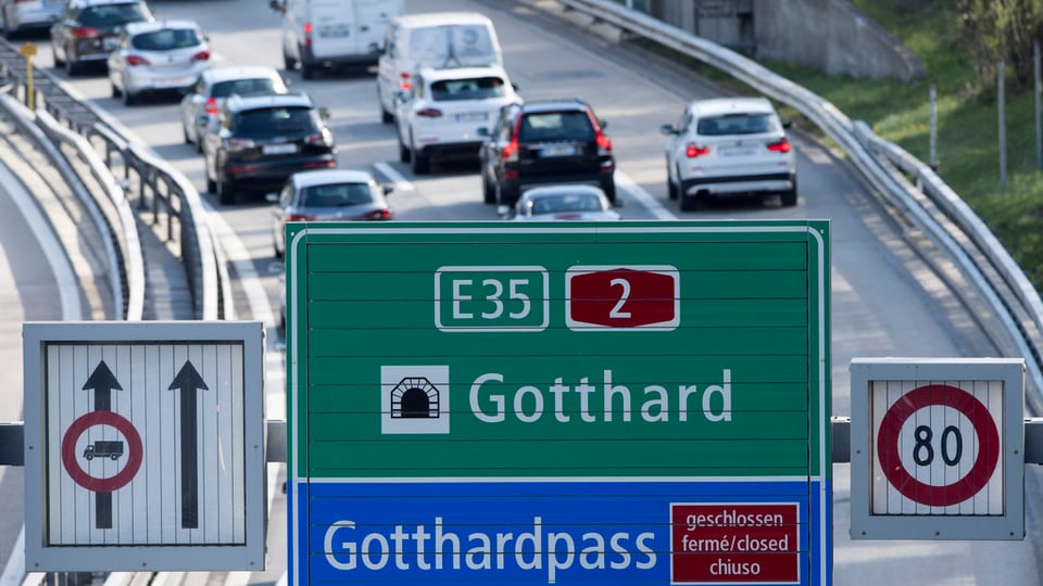 Colonnas sin la ruta dal Gottard, davantvart tabla da via cun il tunnel ed il pass dal Gottard.