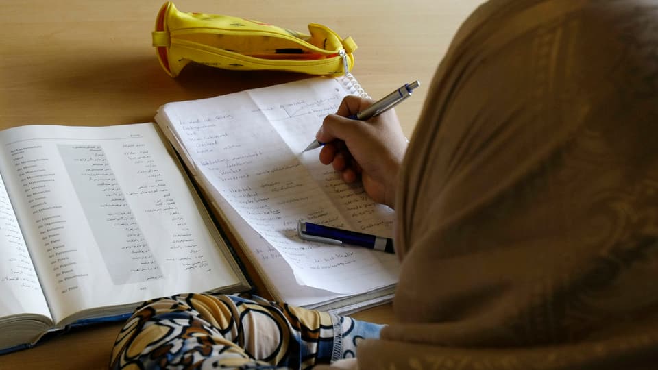 Ina dunna curda che visita in curs da tudestg. Ins vesa la dunna mo da davosen.