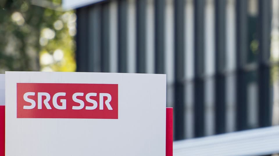 Il logo da la SSR sin ina tabla davant in bajetg da la SSR.