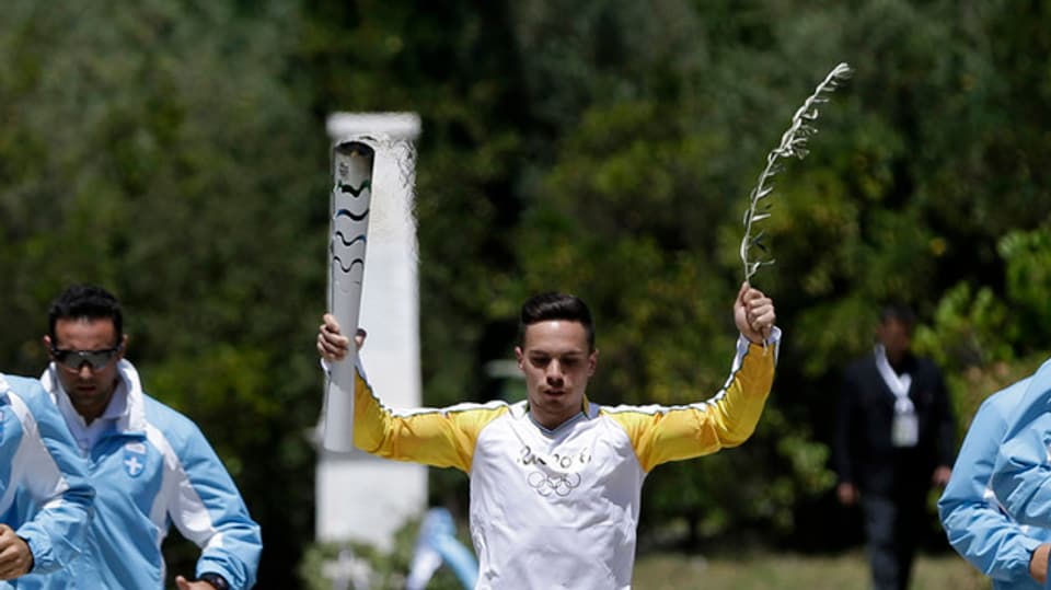 Il gimnast grec cun la flomma olimpica. 