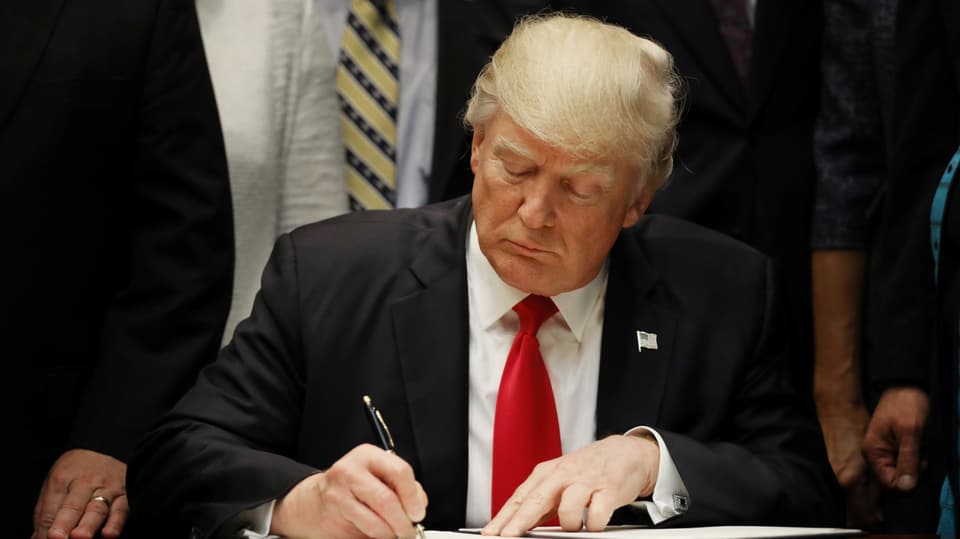 Purtret da Trump che suttascriva il decret.