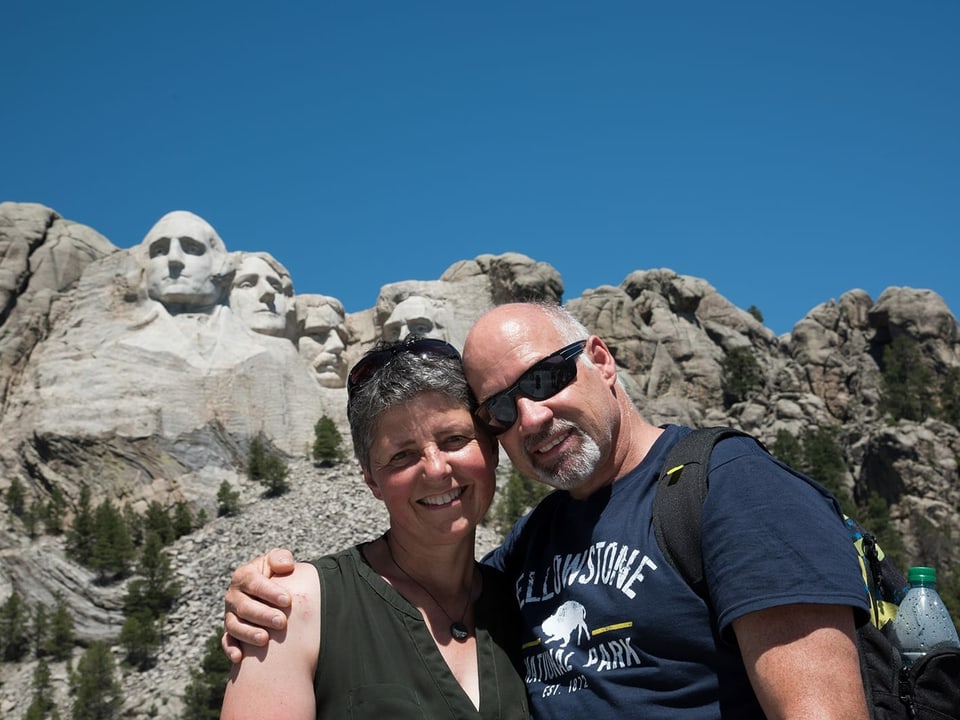 Ida Sgier cun ses um Richard davant las statuas dal Mount Rushmore en l'America.