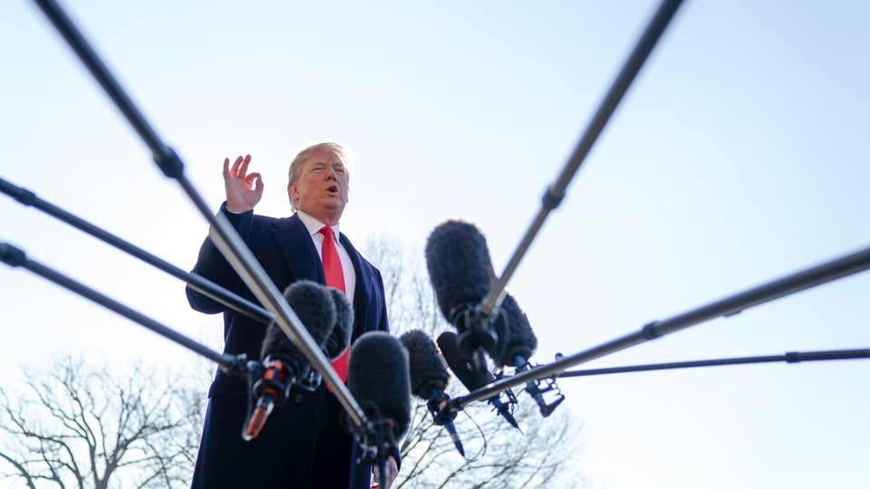 Donald Trump che discurra avant microfons. 