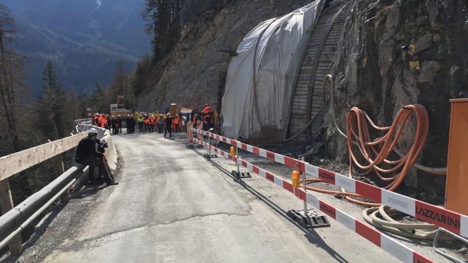 Differentas persunas davant l’entrada dal nov tunnel Val Pischöt che spetgan sin la siglientada.