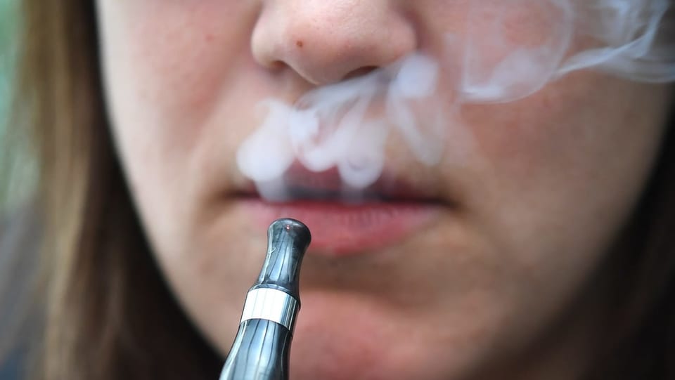 Purtret d'ina dunna che fima ina cigaretta electronica. 