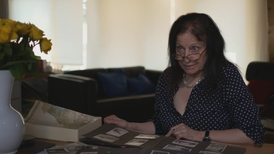 Foto von Sigrid Schlegel-Conradi vor einem Fotoalbum.