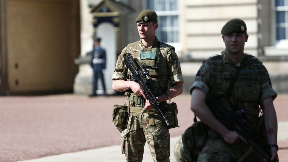 Purtret dal Buckingham Palace e schuldads armads ch'èn postads davantvart. 
