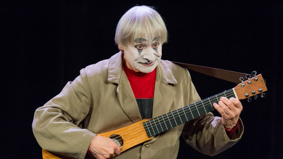 Dimitri Dimitri sin tribuna cun ghitarra.