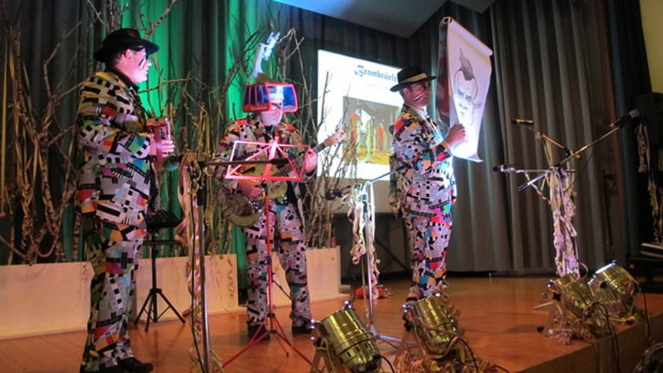 3 umens en costum da tschaiver durant lur producziun da salamuira.
