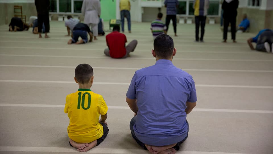 Fugitivs sirians èn sa radunads per urar en ina moschea a Sao Paulo.