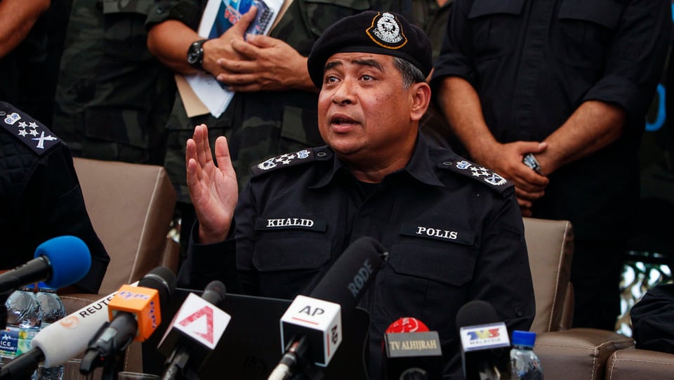 Il schef da la polizia da la Malaisia che discurra envers las medias. Davant el èn blers microfons.