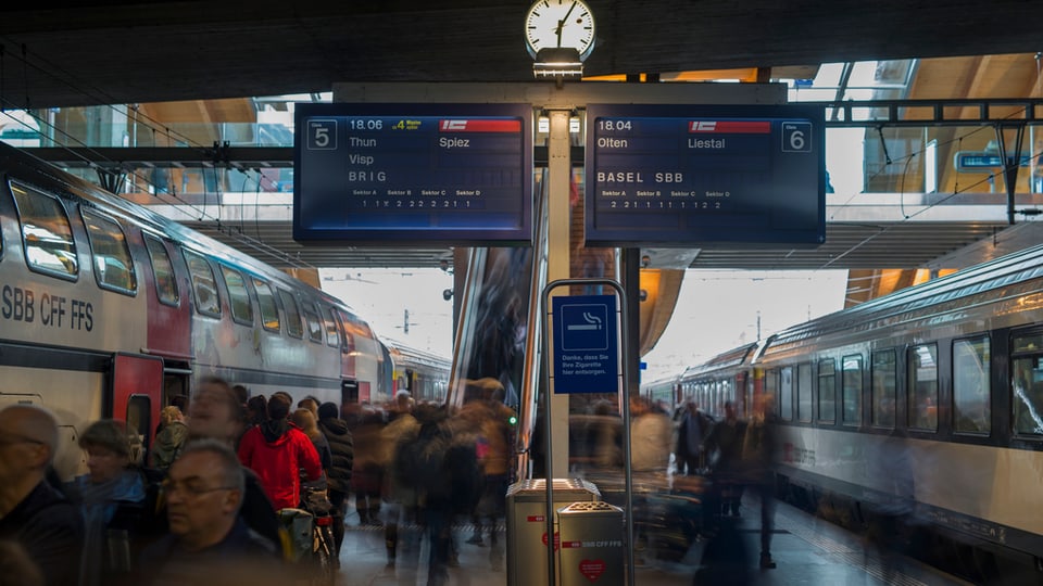 Passagiers che ascendan e descendan ils trens a la staziun da Berna.