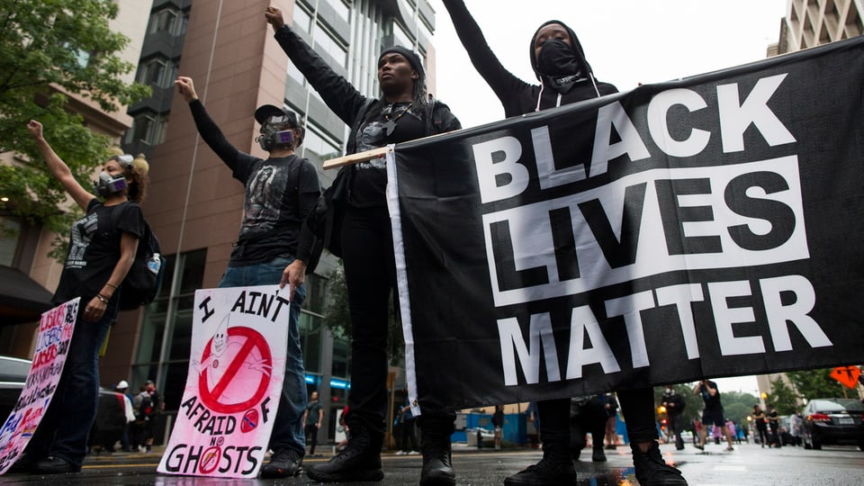 Purtret da quatter persunas che defendan il logo «Black lives matter».