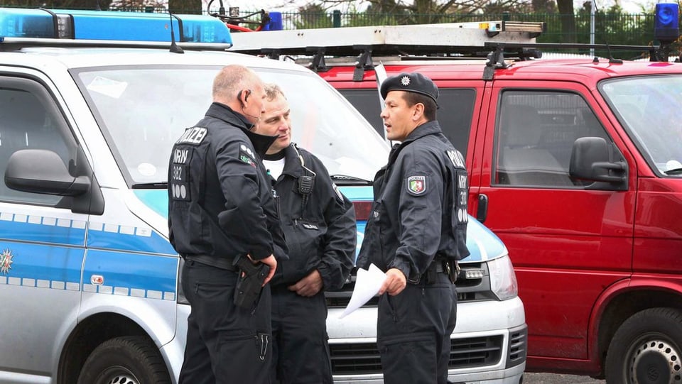 Policists stattan davant in bus da polizia.