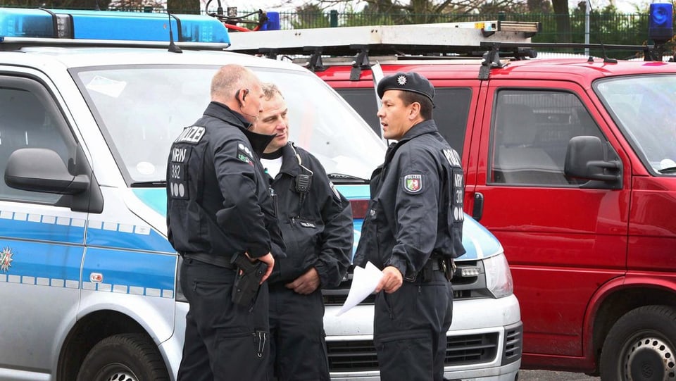 Policists stattan davant in bus da polizia. 