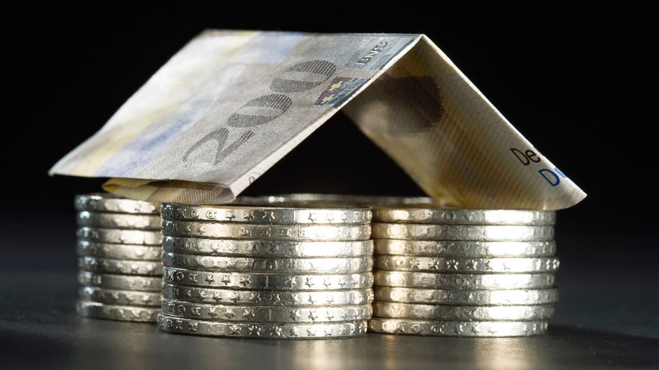 Ina chasa or da quatter plunas cun da 5.- ed ina bancnota da 200.- sco tetg