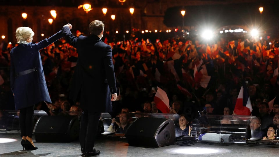 Emmanuel Macron e sia dunna sa laschan festivar en in stadion datiers dal Louvre. 