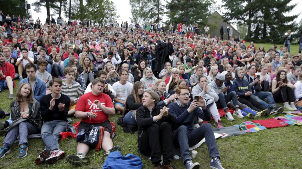 Giuvenils visitan il champ sin l'insla norvegiaisa Utøya.