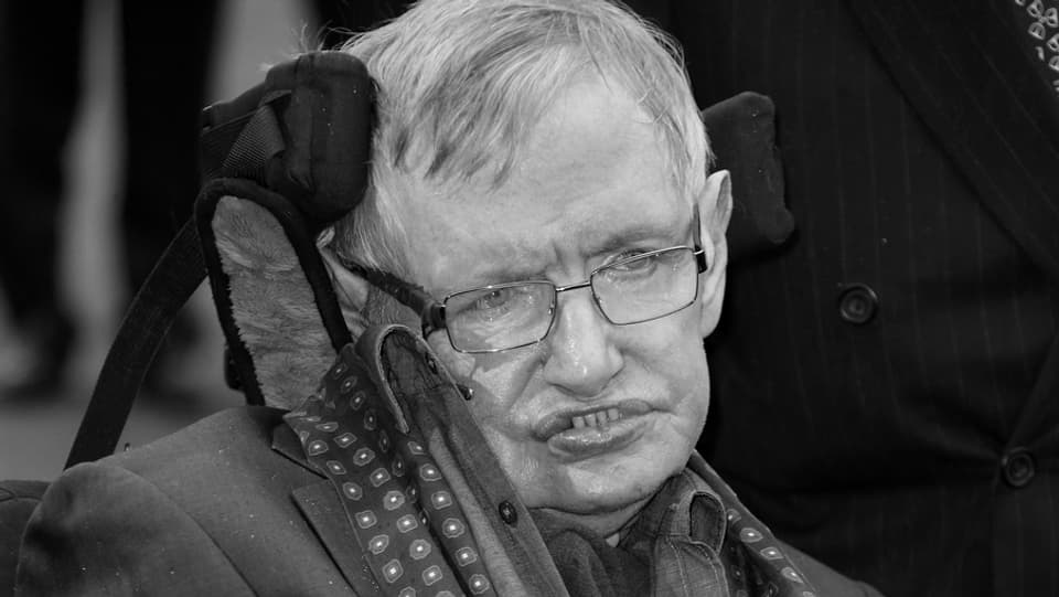 Purtret da Stephen Hawking en sutga da rodas. 
