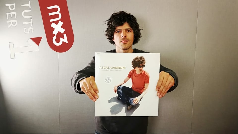Purtret da Pascal Gamboni che tegn sia nova platta enta maun.