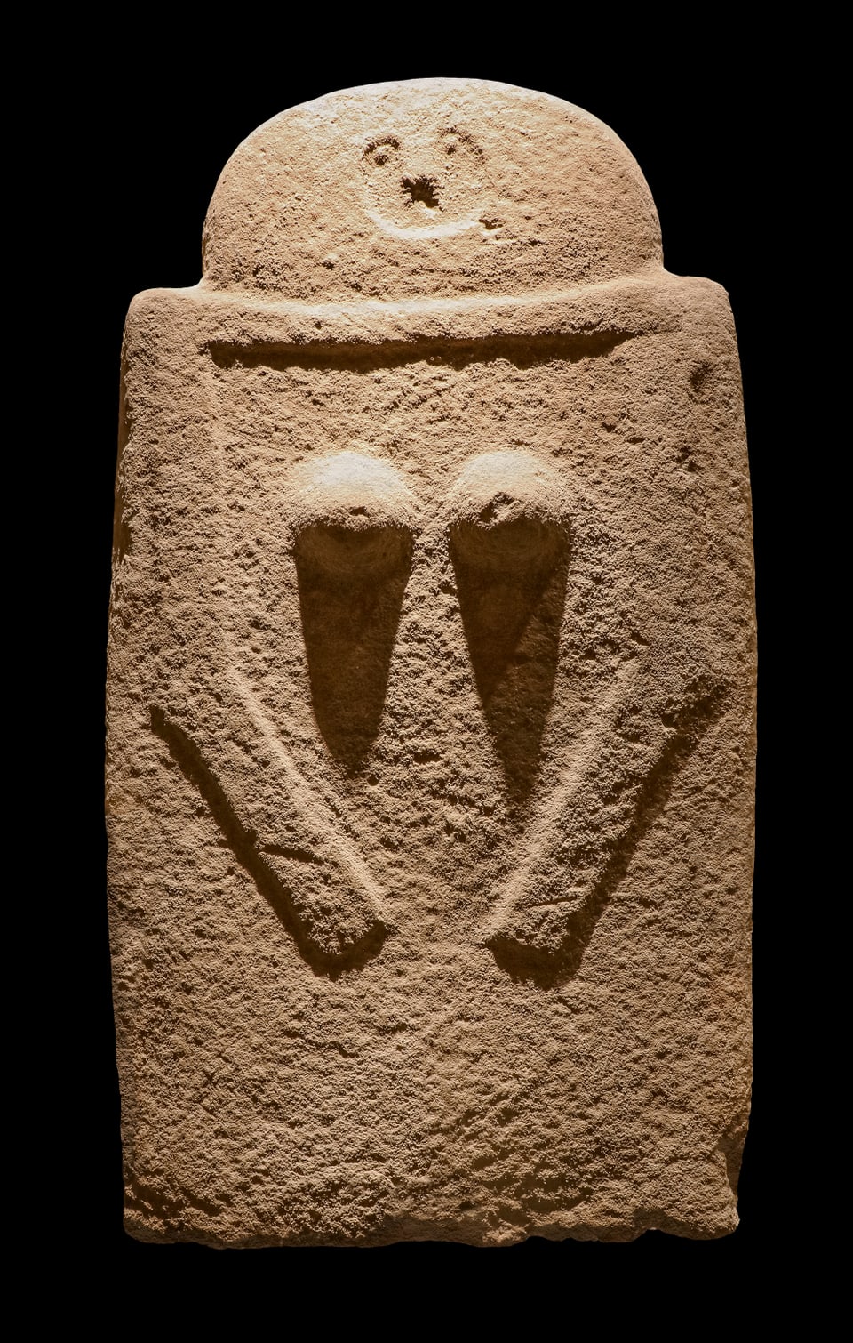 Stela feminina cun fatscha en furma d'u, sains e bratscha. Crap da sablun. 3000–2000 a.C. Italia, Toscana, Fivizzano.