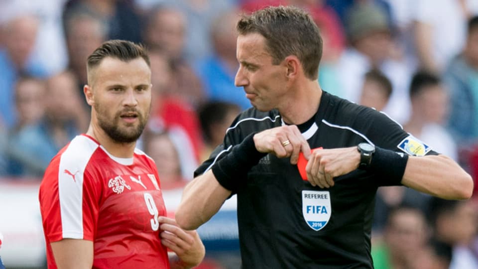 l'arbiter Paoloa Silvio Mazzoleni mussa la carta cotschna a'l svizer Haris Seferovic.
