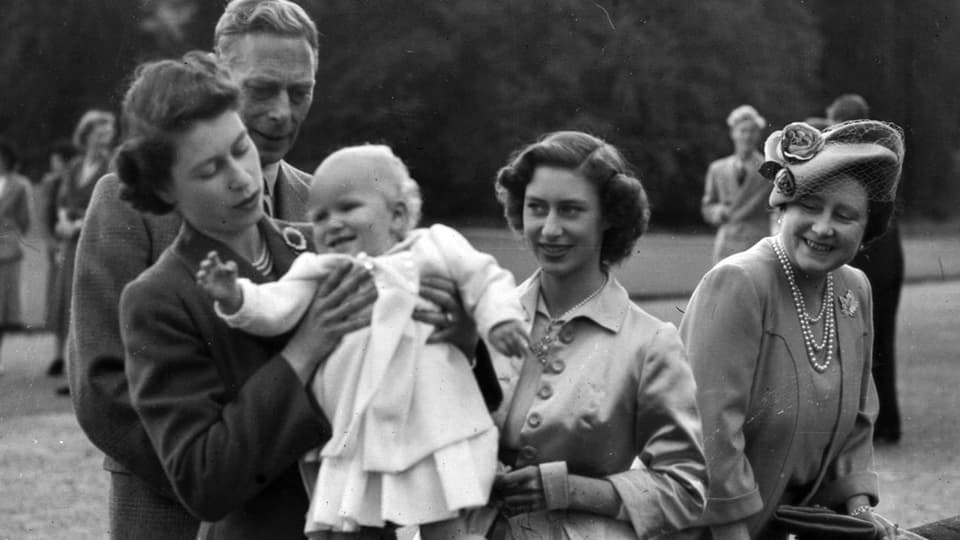Davant Queen Elizabeth II che tegn sia figlia Anne. Davostiers ses bab King George VI, daspera la sora Princess Margaret e sper lezza la mamma Queen Elizabeth. 