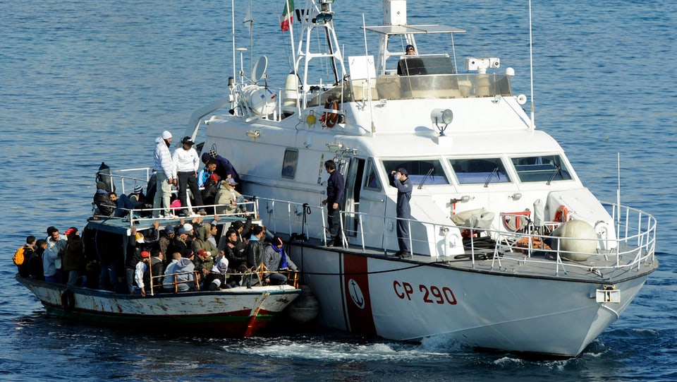 bastiment da la guardia da costa taliana che maina cun in bastiment da fugitivs 