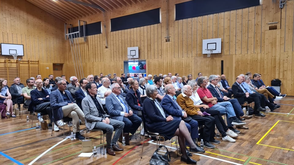 Die Mehrzweckhalle ist gut gefüllt, vorne sitzen die zwei geehrten Alexi Decurtins e Gion Tscharner. 