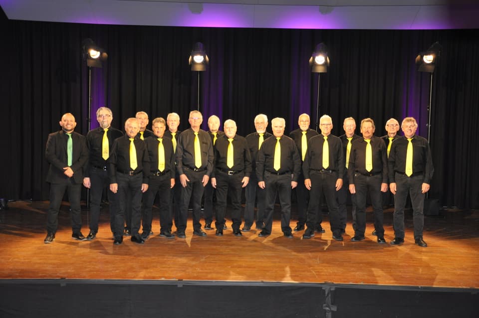 Männerchor, Chor dals Paslers, gekleidet in schwarz mit gelben Krawatten