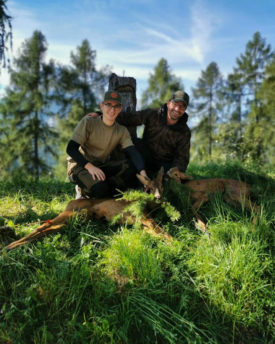 Zwei Männer (Jäger) mit zwei erlegten Rehgeissen im Wald