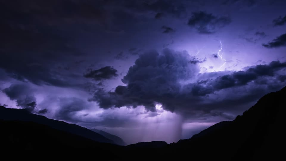 Blitzgewitter in lila Wolken bei Castrisch Richtung Chur