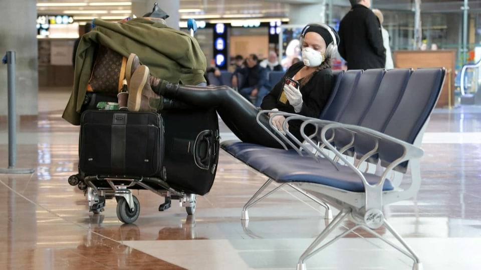 viagiatur cun mascra da protecziun a la plazza aviatica vid spetgar