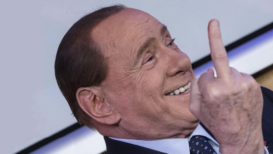 Silvio Berlusconi mussa il det amez durant ina preschentaziun d'in cudesch il schaner 2016.