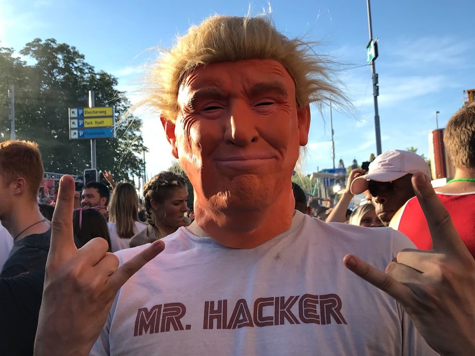 persuna cun mascra da Donald Trump e text: Mr. Hacke sin il shirt