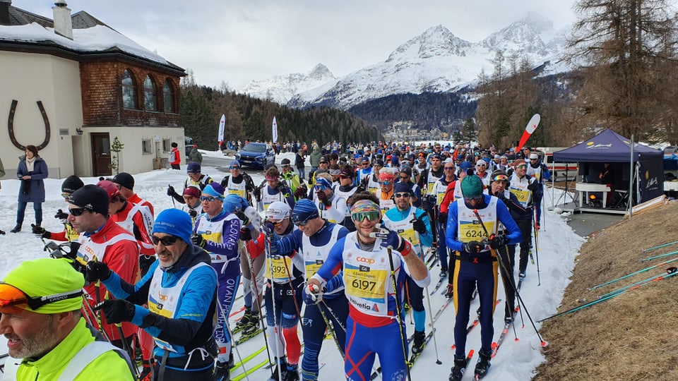 Langläufer am Engadiner Skimarathon warten an einer Engstelle.