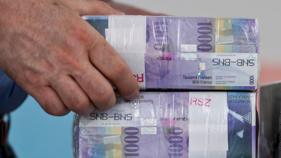 In maun che tegna faschs da bancnotas svizras da milli.