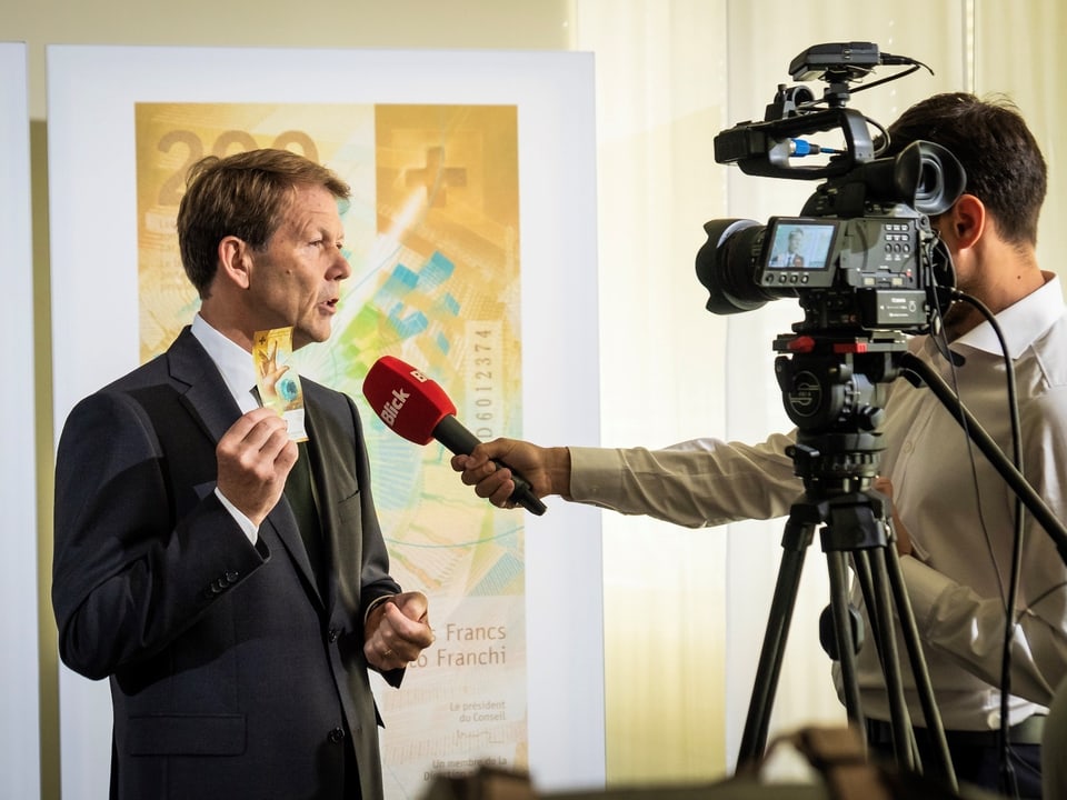 Fritz Zurbrügg mussa la nova bancnota da 200 francs al journalist.