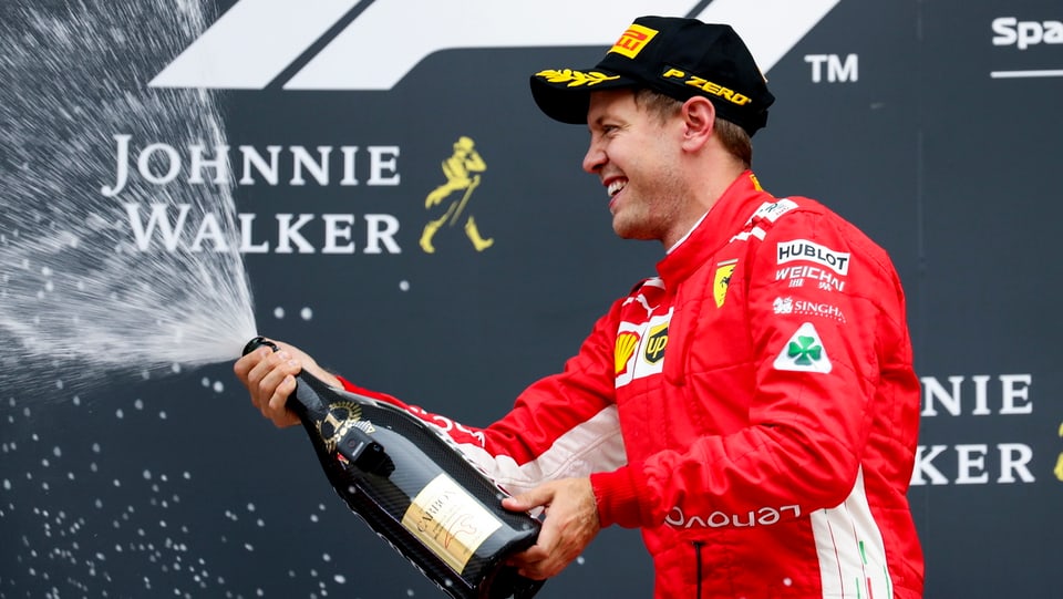 Sebastian Vettel cun ina buttiglia da Champagner. 