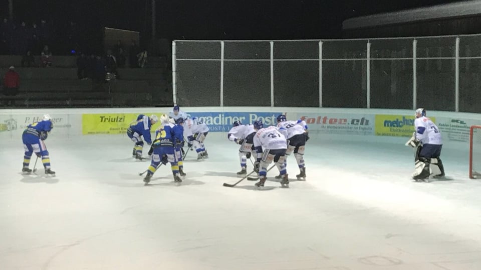Duas equipas cumpattan per il possess dal puck.