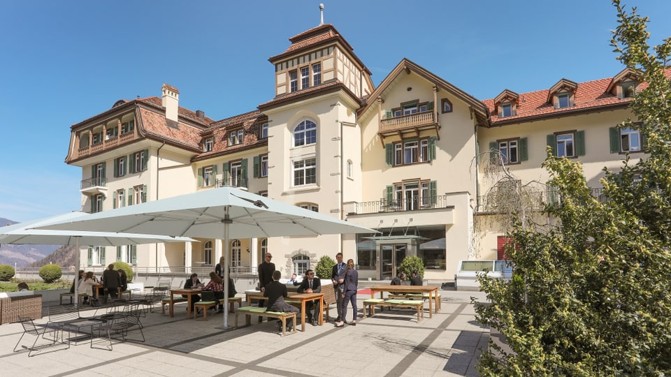 La scola cun restaurant da terrassa davant.