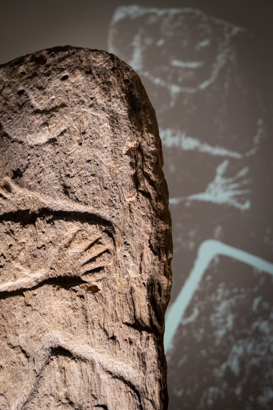 Stela probablamain masculina cun fatscha rienta, figura arcaica, stilisada cun bratscha, mauns ed ina cuntgadella. 