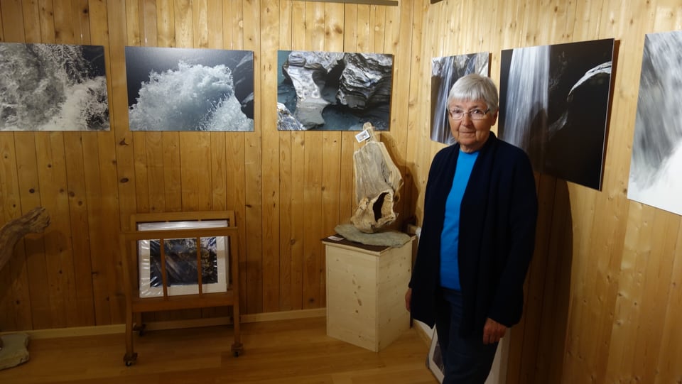 La curatura da la Gallaria Toissa Heidi Wenig davant maletgs dal fotograf Bernd Egger.