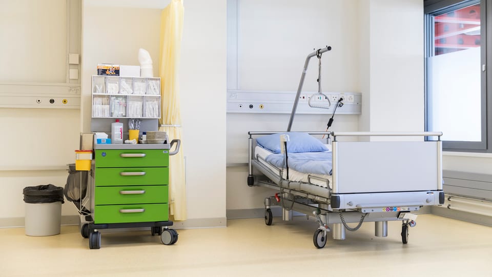 Ina stanza d'ospital cun let e maisina da notg.