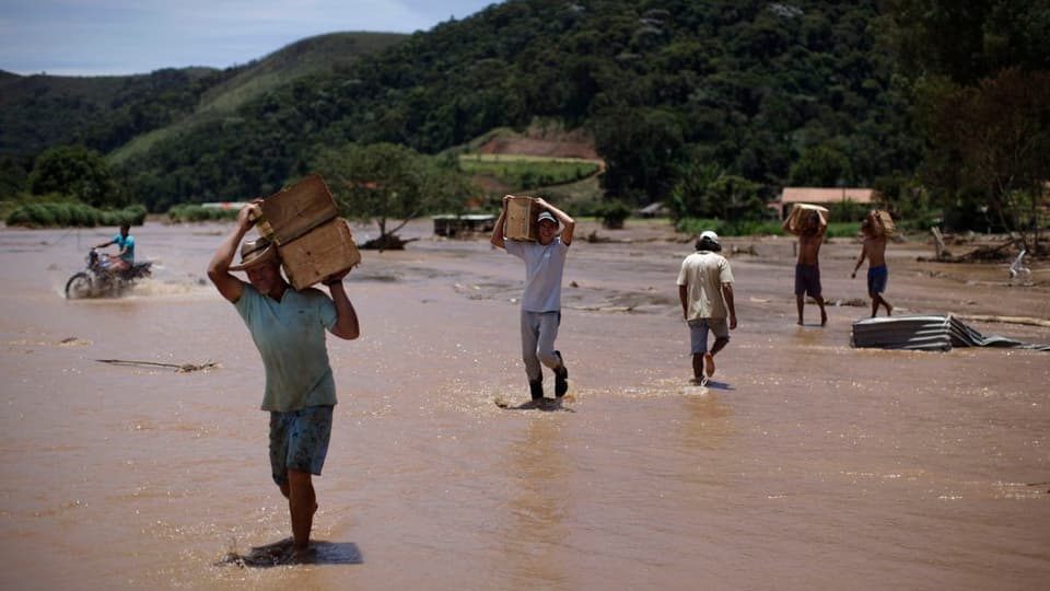 Persunas che cumbattan cunter las inundaziuns. 